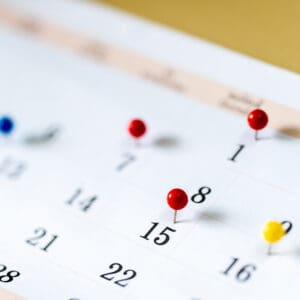 A calendar with many pins on it