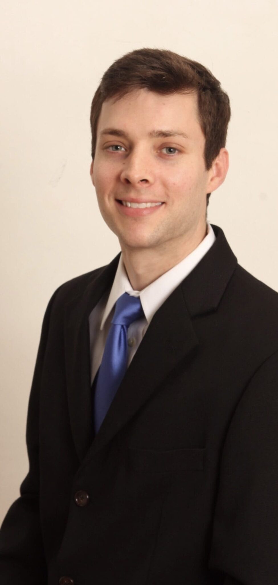 A man in a suit and tie smiling for the camera.